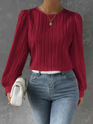 Burgundy pleated blouse with gathered shoulders and long sleeves.