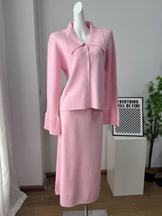 Pink ribbed knit cardigan with collar and button-down front, paired with a matching midi skirt.