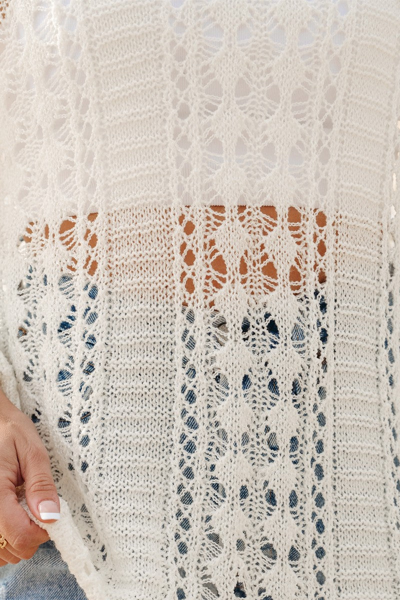 Openwork knit beach cover-up in beige with intricate lace-like patterns.