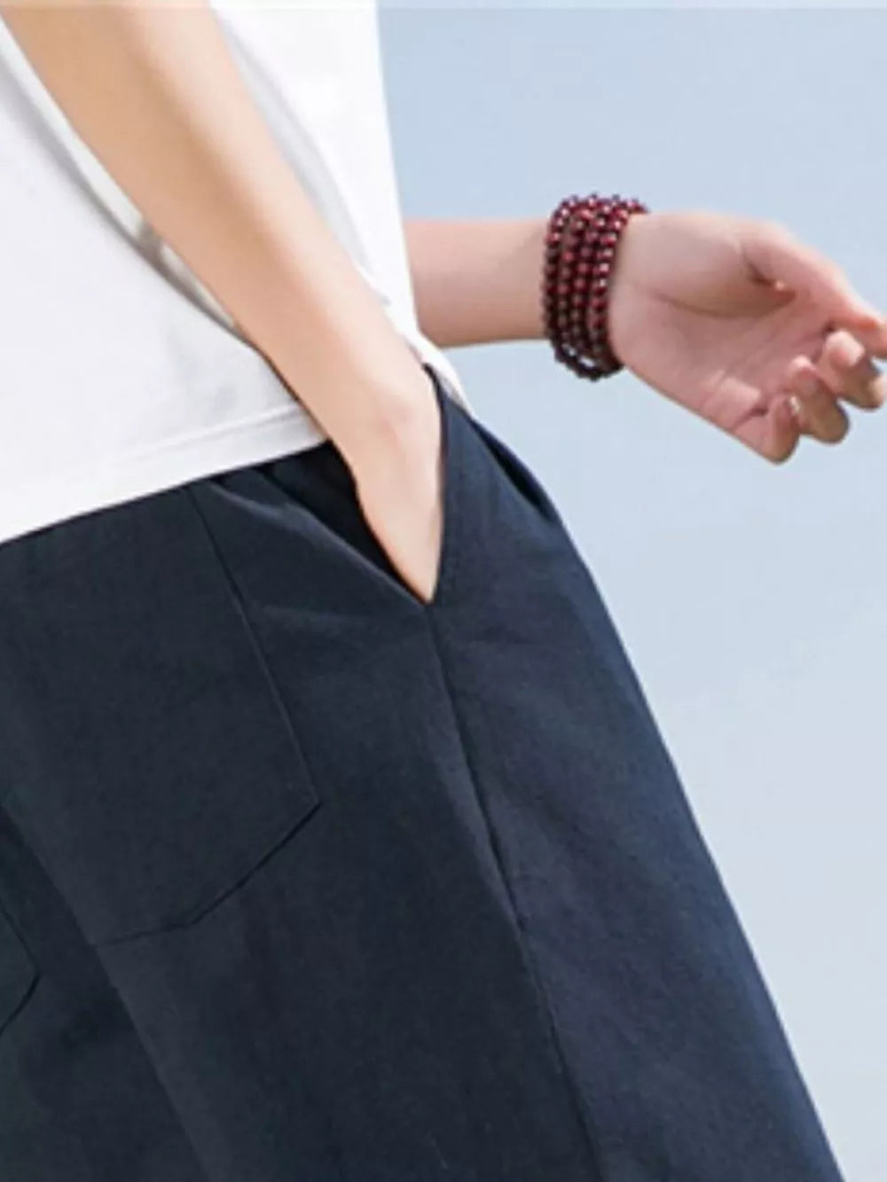 Navy blue men's sweatpants with drawstring and pockets, worn with a white t-shirt.