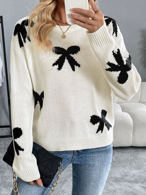 Cream acrylic crewneck sweater with scattered black bow pattern.