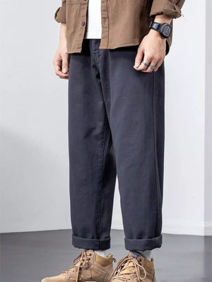 Dark gray cotton wide-leg trousers with cuffed hems, styled with sneakers.