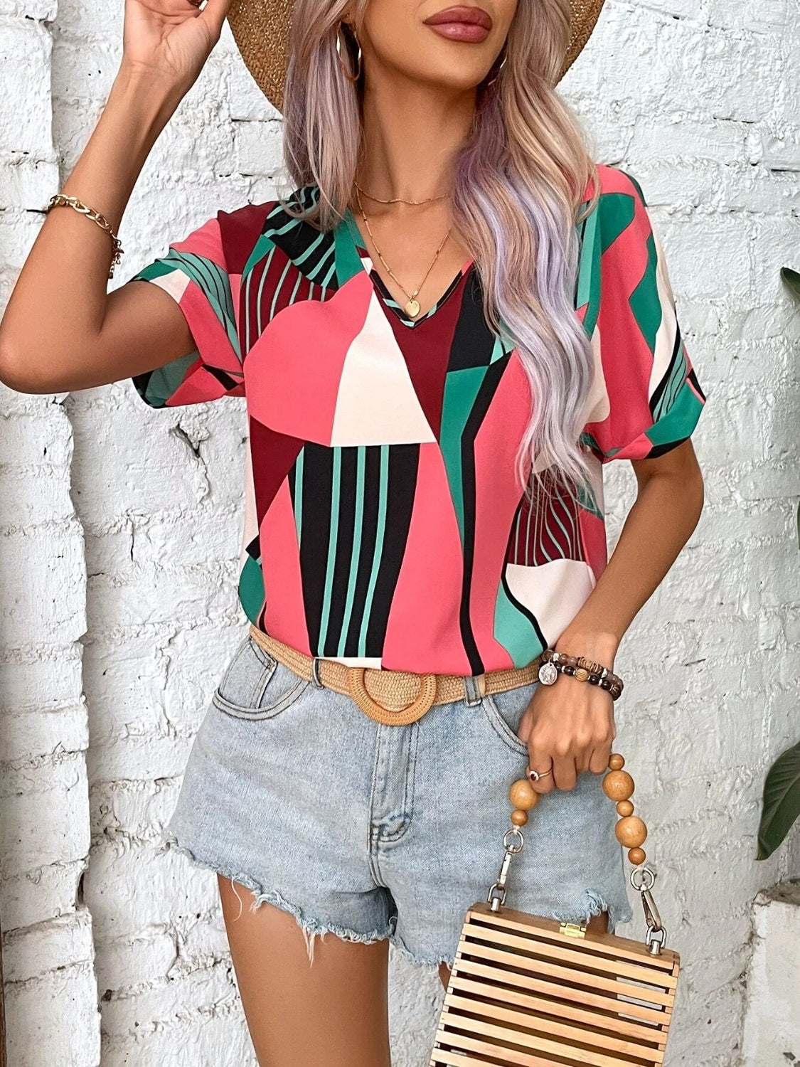 Geometric print V-neck blouse in multicolor with short sleeves.