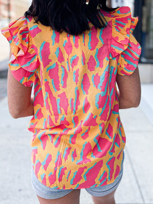 Neon abstract ruffle sleeve blouse in multicolor with pink and teal animal print on orange.