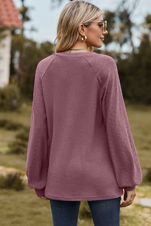 Burgundy waffle knit raglan top with diamond eyelet sleeves and V-neck.