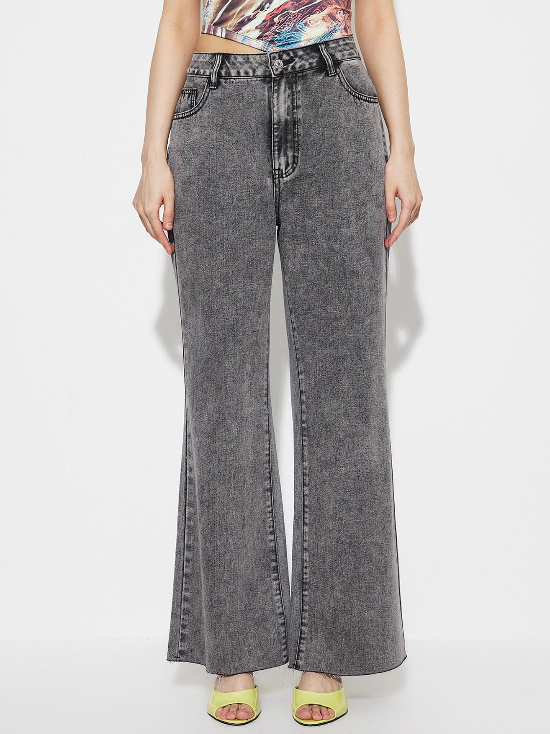 Acid wash flare jeans in dark gray cotton with a high-rise fit and buttoned front.