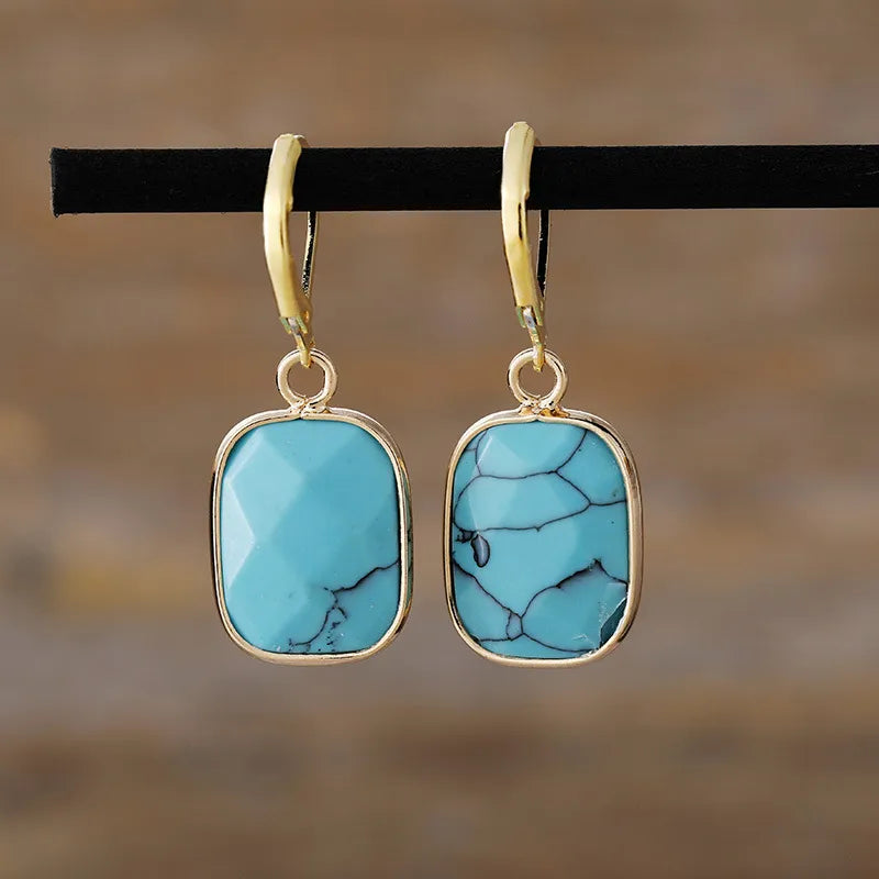 Turquoise stone drop earrings with gold plating and unique veining detail.