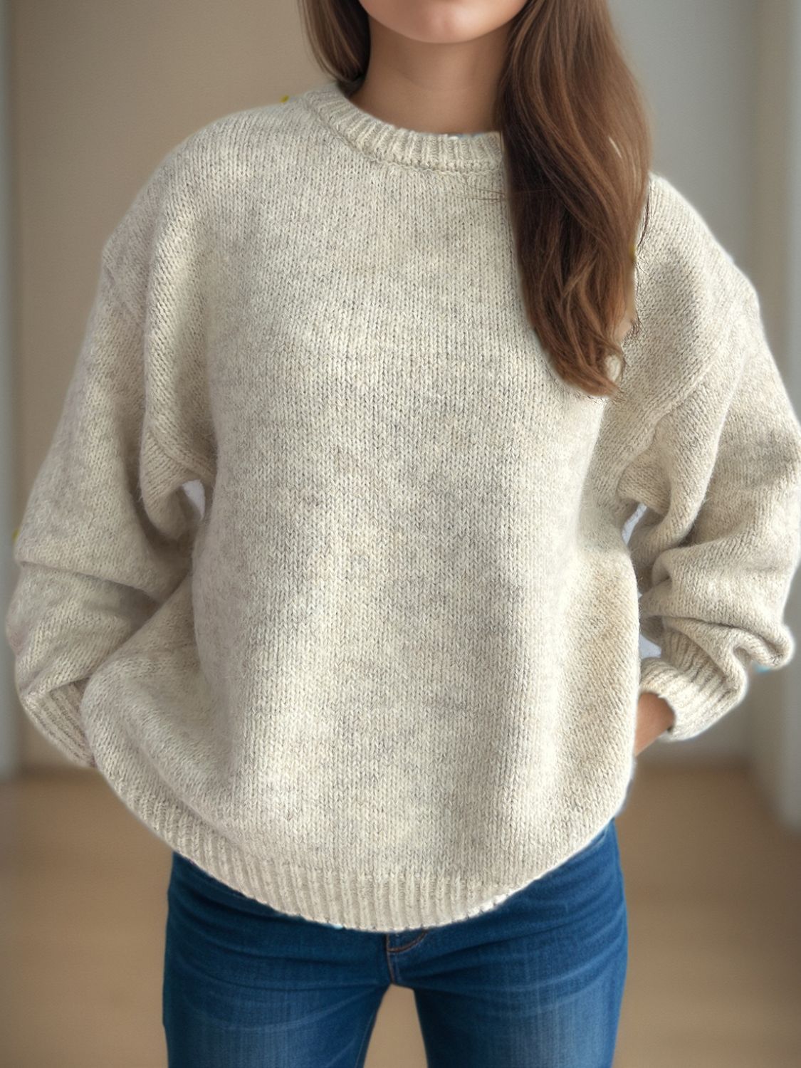 Oversized beige crewneck sweater with textured knit and ribbed cuffs.