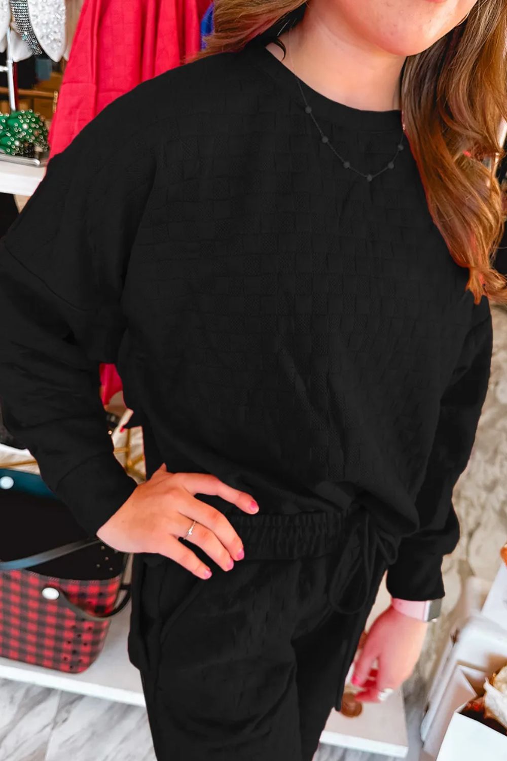 Black textured weave loungewear set with crew neck sweatshirt and drawstring pants.