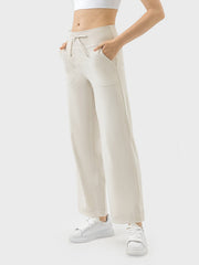 Cream wide-leg drawstring active trousers with pockets and a relaxed fit.