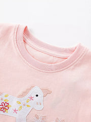 Pink cotton baby dress with embroidered unicorn and floral details.