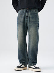 Men's relaxed fit vintage wash denim jeans with distressed details.