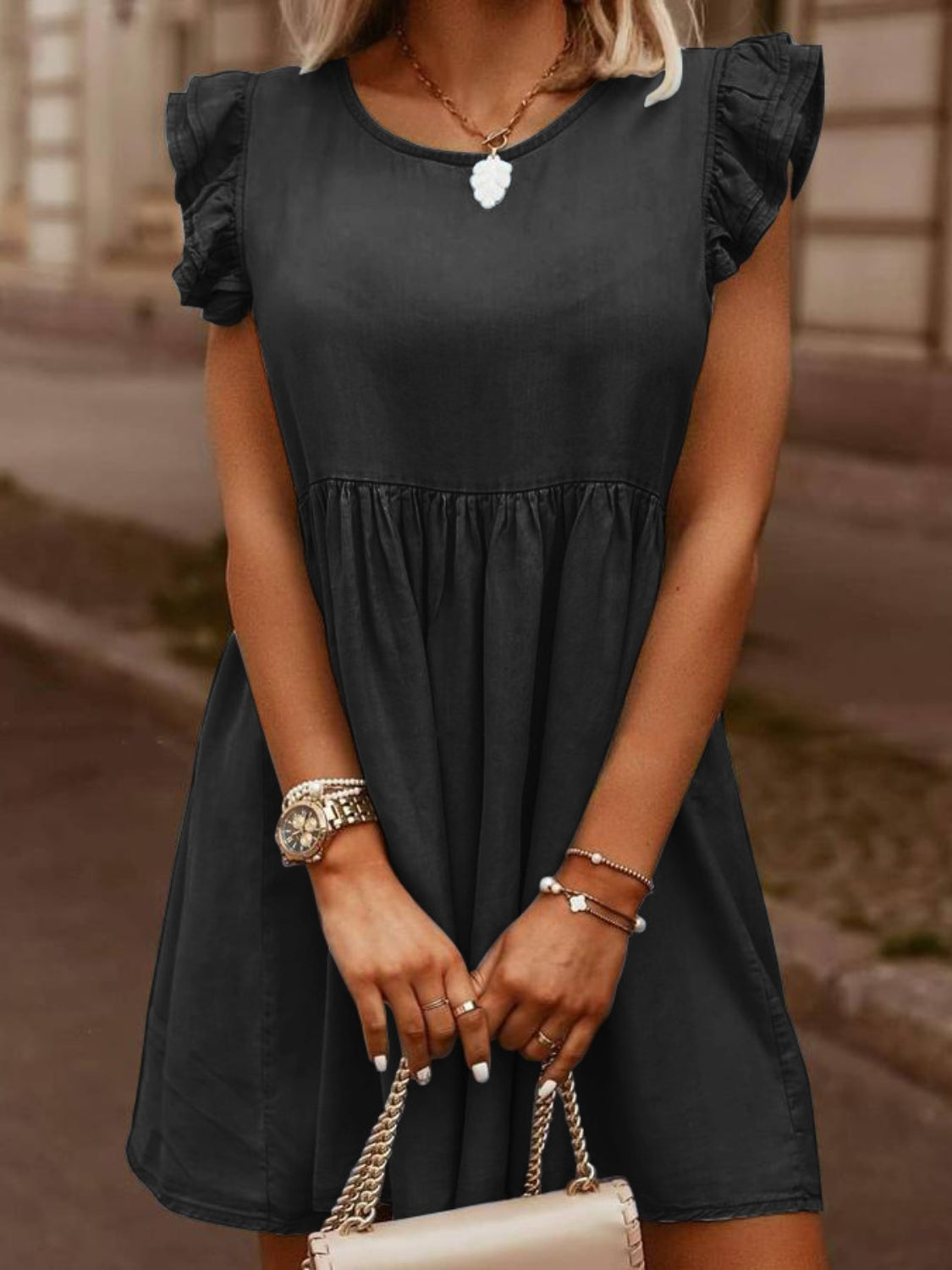 Black denim babydoll dress with ruffled short sleeves and a gathered waist.