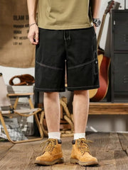 Men's black relaxed fit drawstring shorts with contrast stitching and cargo pocket.