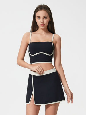 Black contour-trimmed crop top with white piping and thin straps.