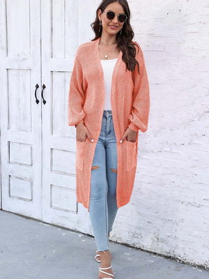 Ribbed knit maxi cardigan in Sherbet with pockets and open front, styled with jeans.