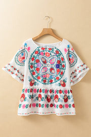White peplum blouse with embroidered medallion and floral print, ruffle sleeves.