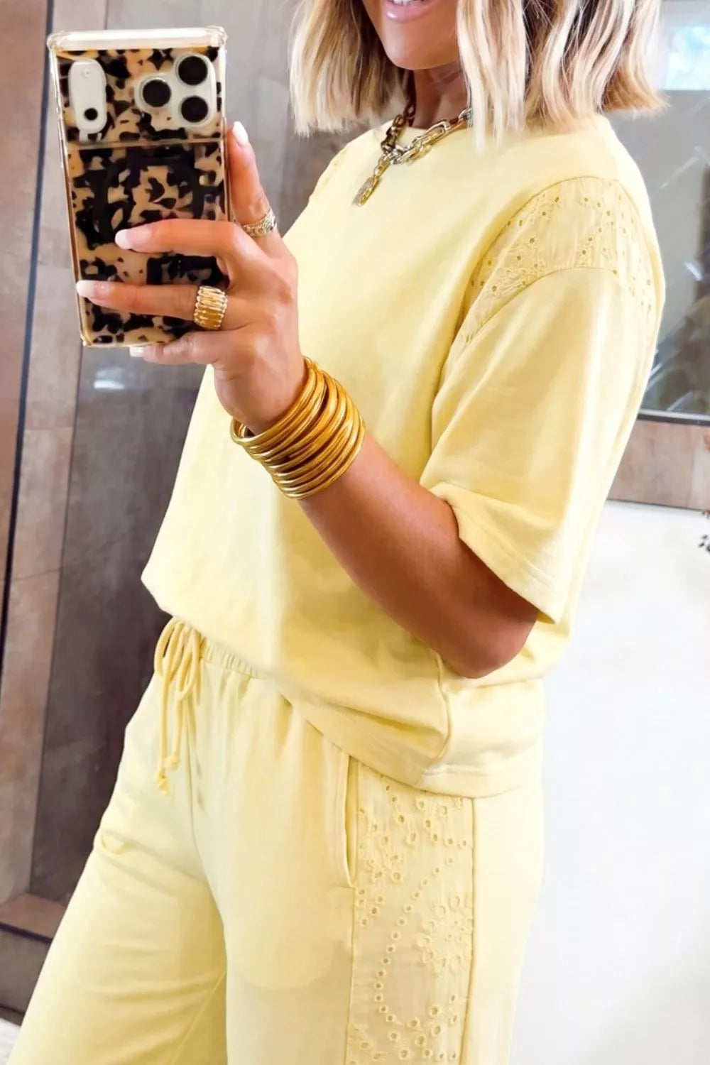 Yellow cotton embroidered half-sleeve top and drawstring pants ensemble with eyelet details.