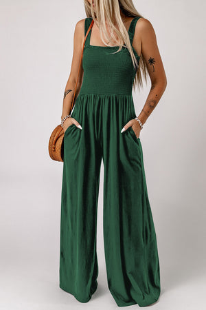 Green smocked square neck wide leg jumpsuit with pockets and spaghetti straps.