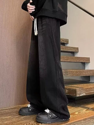 Men's black wide leg jeans with drawstring waist and white laces.