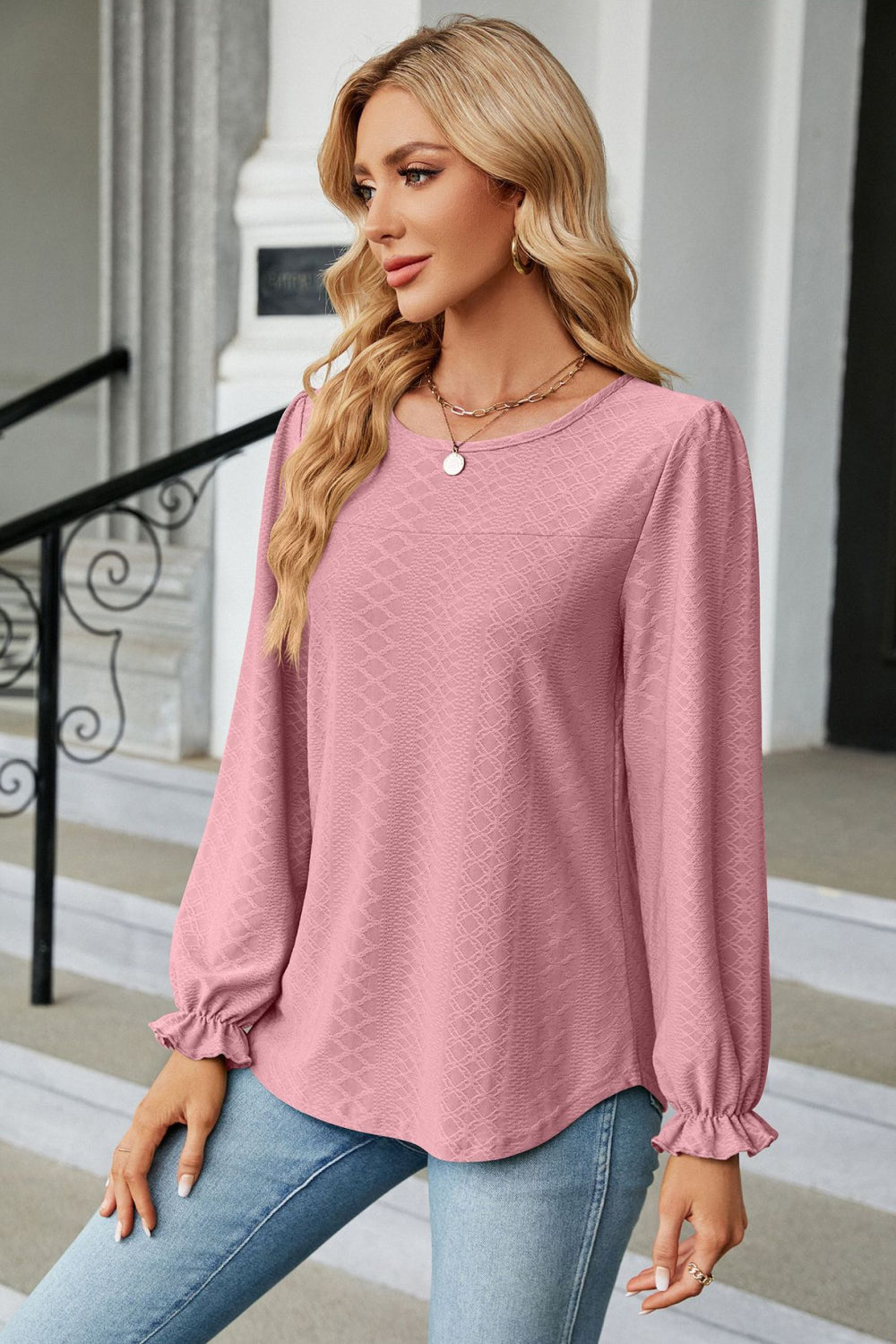 Pink textured puff sleeve blouse with ruffle cuffs and crew neck.