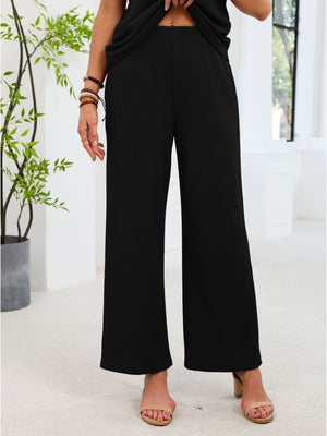 Black wide leg pants with cutout detail, part of a two-piece set.