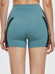 Turquoise activewear shorts with black side stripe detail and V-shaped seam.