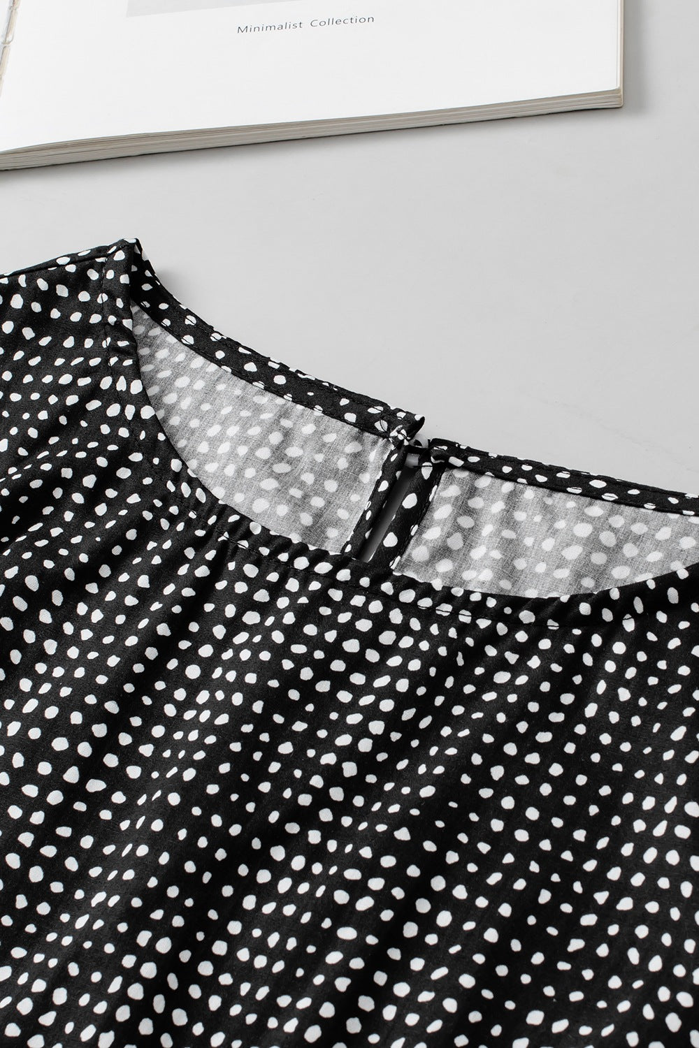 Black dotted blouse with a square neckline and keyhole detail