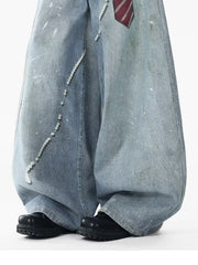 Oversized denim jeans with pearl accents and paint splatters.