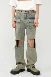 Distressed medium wash denim cargo jeans with cut-outs and raw hem.