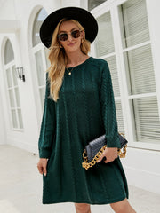 Cable knit A-line sweater dress in Black Forest green with long sleeves and crew neck.