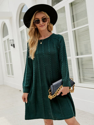 Cable knit A-line sweater dress in Black Forest green with long sleeves and crew neck.