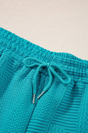Turquoise textured co-ord shorts with drawstring waist and chevron pattern detail.