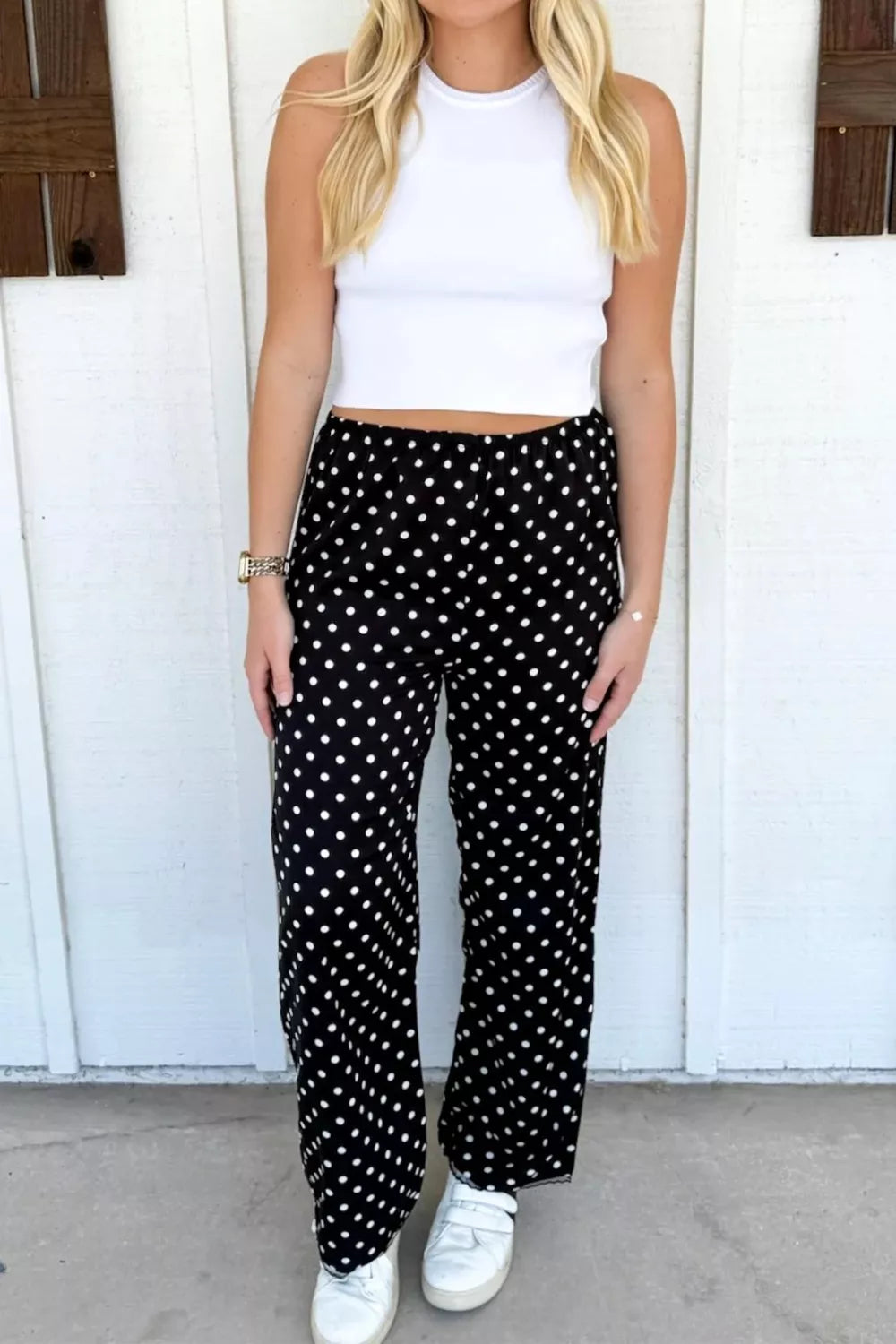 Chic polka dot wide-leg maternity trousers in black with white dots, featuring a comfortable elastic waist.