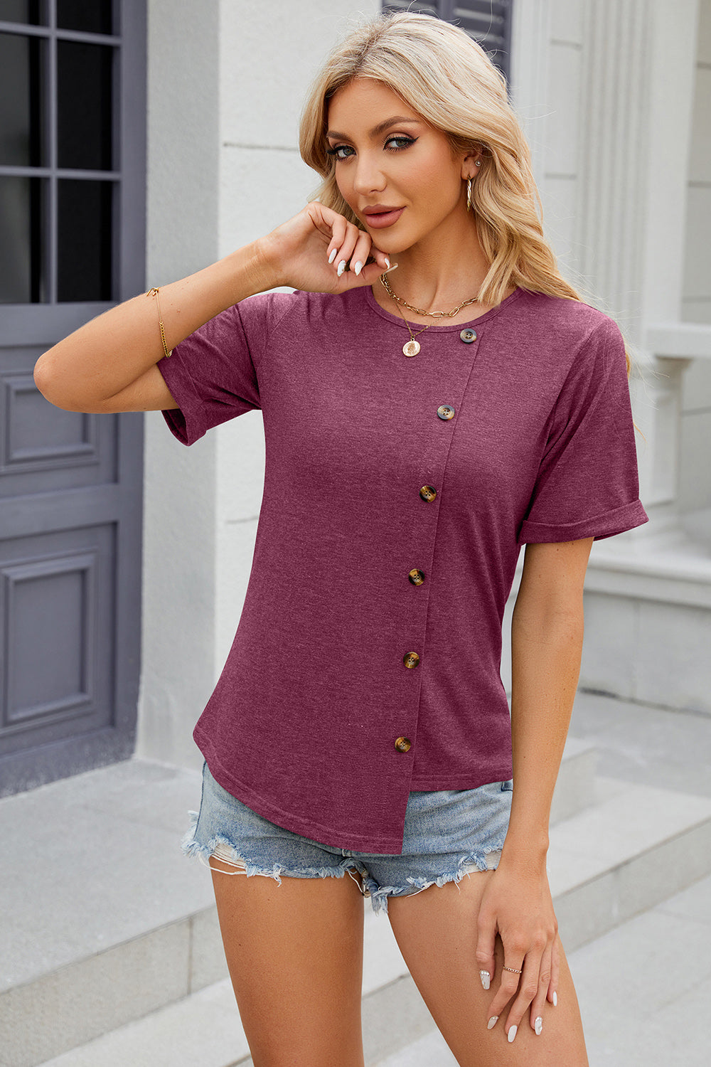Burgundy asymmetric button-up tee with short sleeves and a rounded neckline.