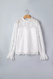 White lace blouse with ruffled neckline and cuffs, long sleeves.
