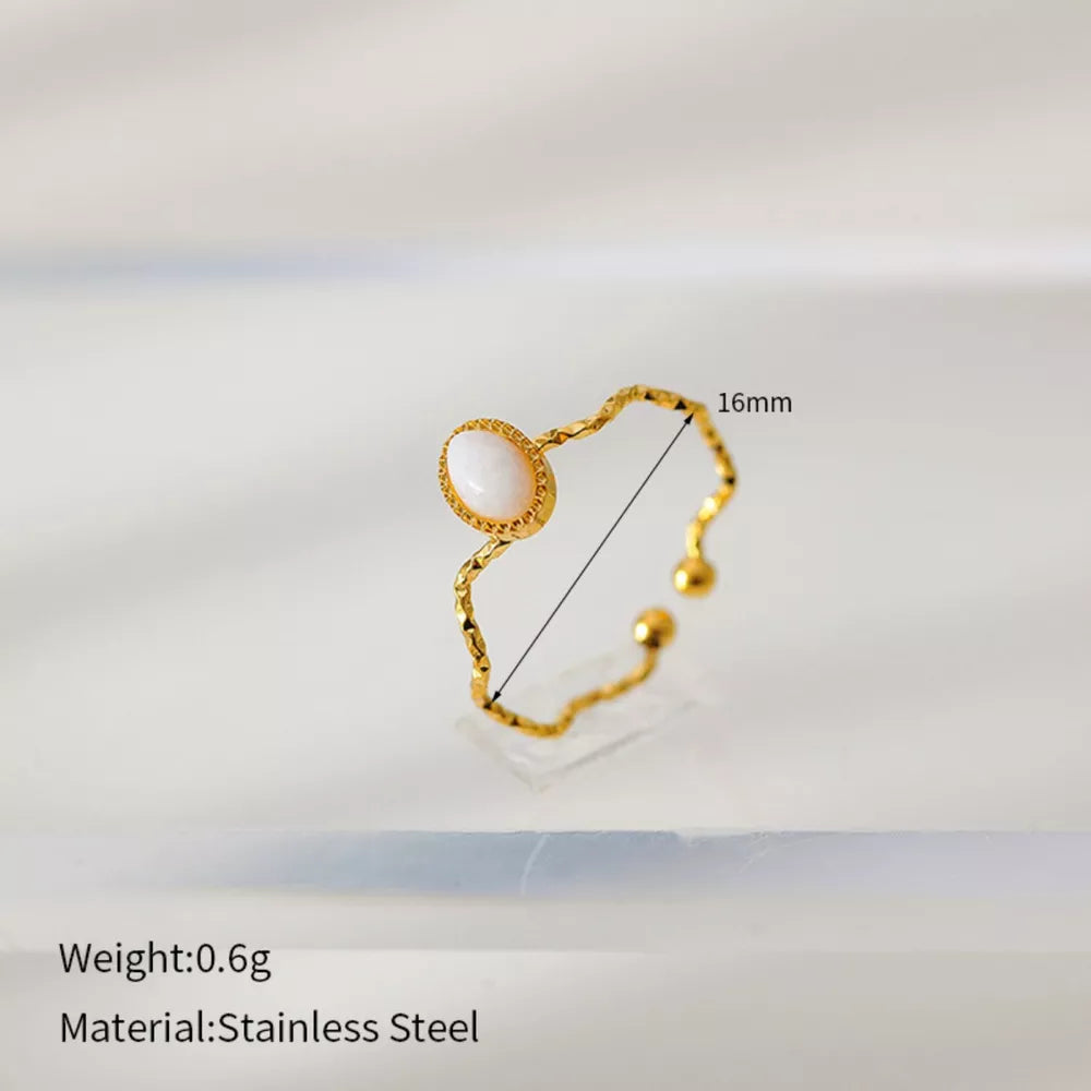 Wavy gold-plated ring with oval cream natural stone, adjustable stainless steel band