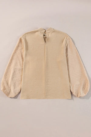 Tan textured blouson top with Swiss dot sheer balloon sleeves and mock neck.
