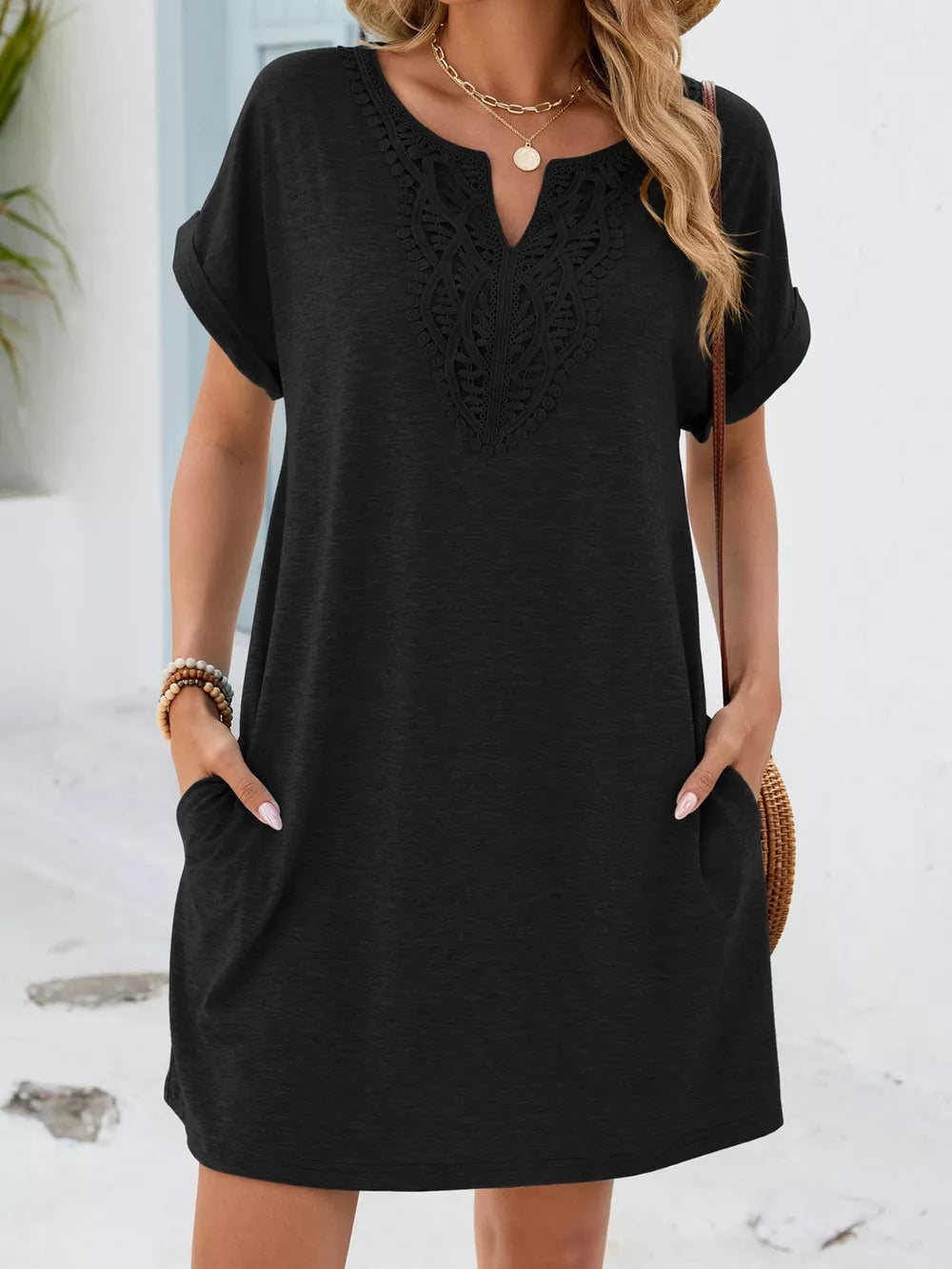 Black lace-trimmed V-neck pocket dress with short sleeves and cuffed hems.