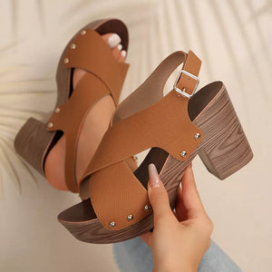 Brown crisscross high heel sandals with studs and adjustable strap.