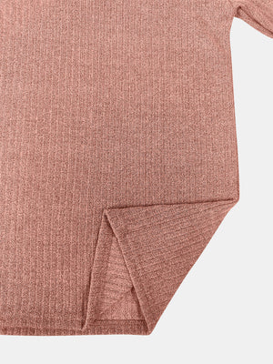 Ribbed knit pullover in burnt coral with side slit detail.