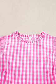 Fuchsia pink gingham blouse with ruffled neckline and smocked short sleeves.