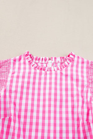 Fuchsia pink gingham blouse with ruffled neckline and smocked short sleeves.