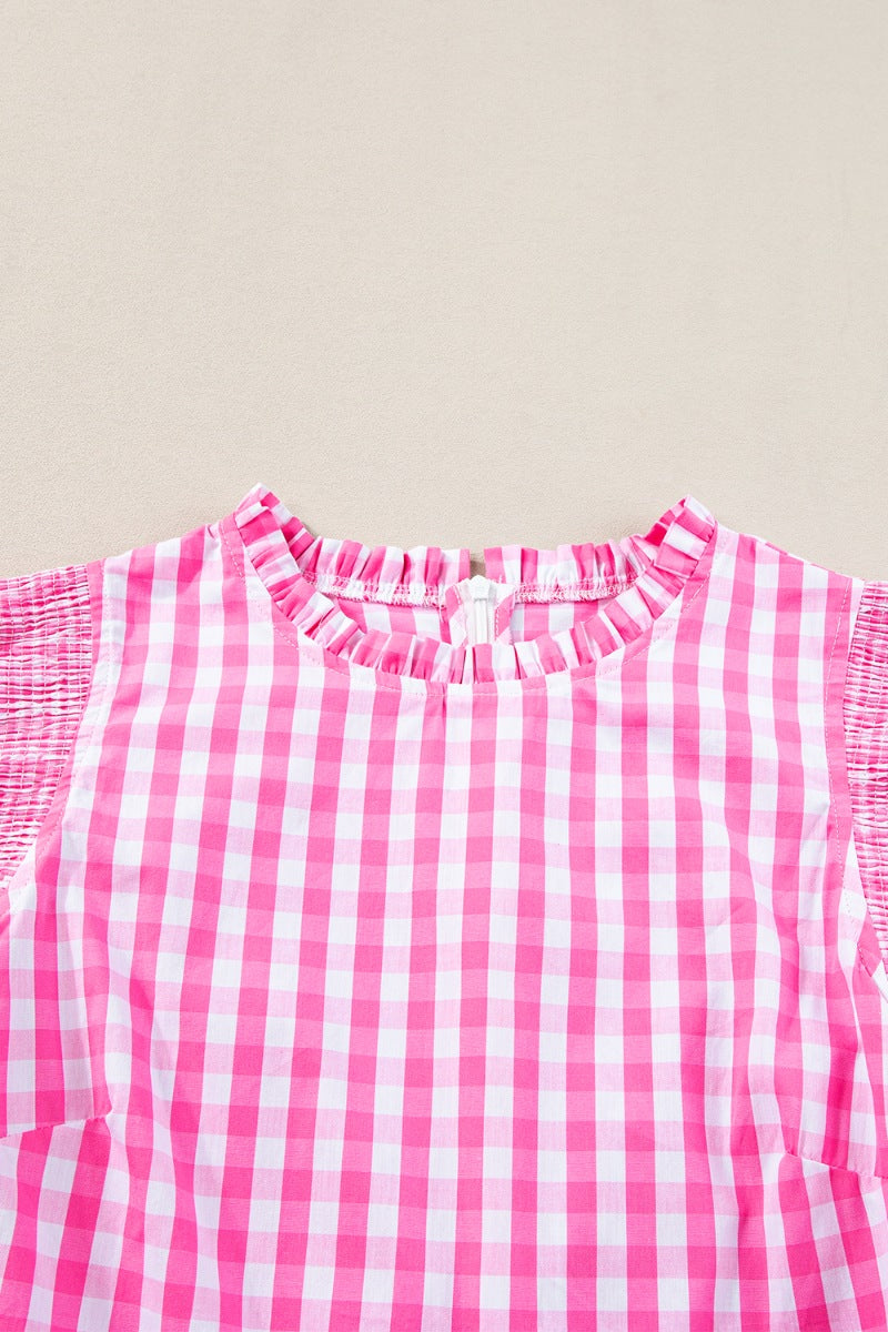 Fuchsia pink gingham blouse with ruffled neckline and smocked short sleeves.
