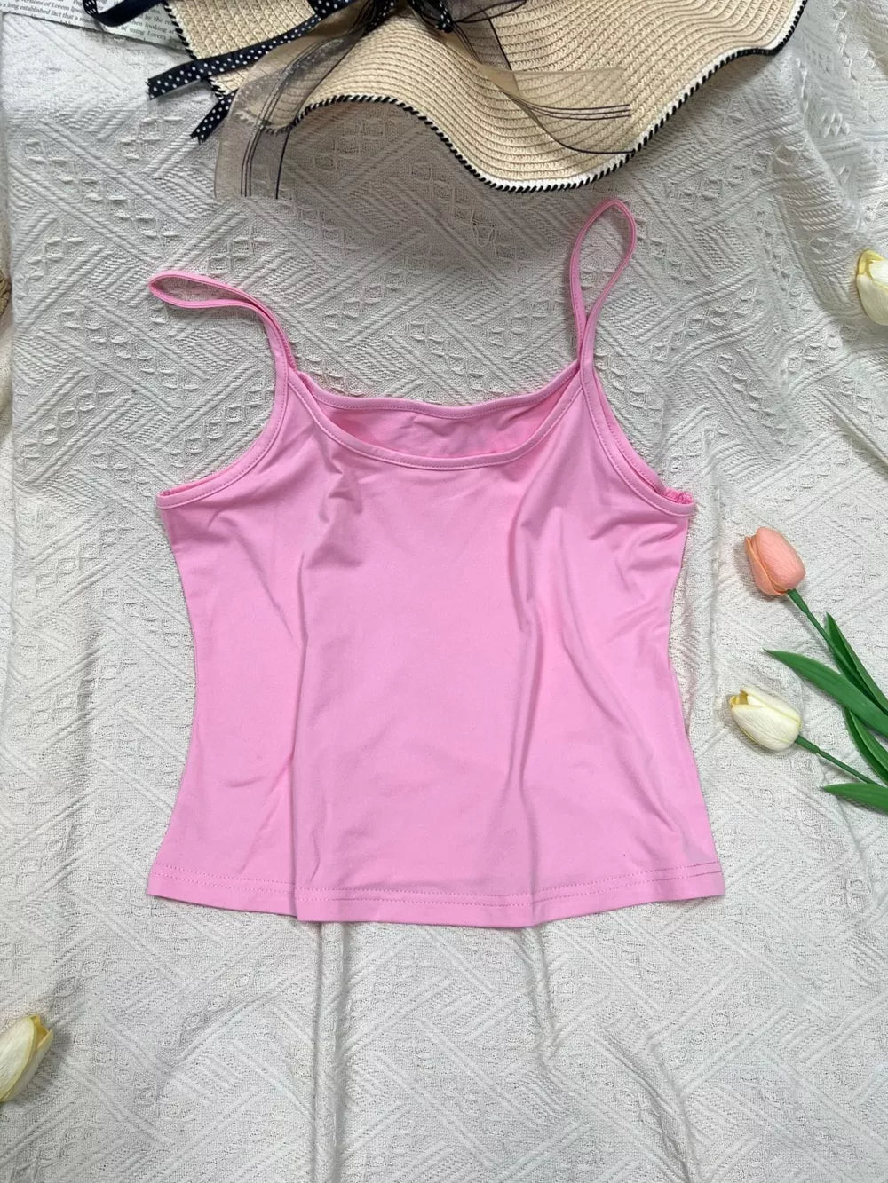 Pink cami top with scoop neck and thin straps.