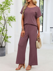 Plum purple lace cutout two-piece set with wide leg pants and short sleeve top.