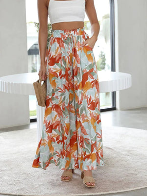 Palazzo trousers with a brushstroke pineapple print in orange and turquoise, featuring a drawstring waist and wide legs.