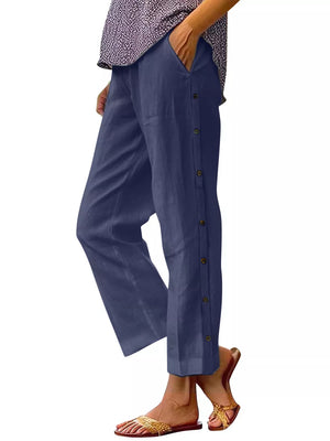 Navy blue relaxed fit pants with decorative side buttons and pockets.