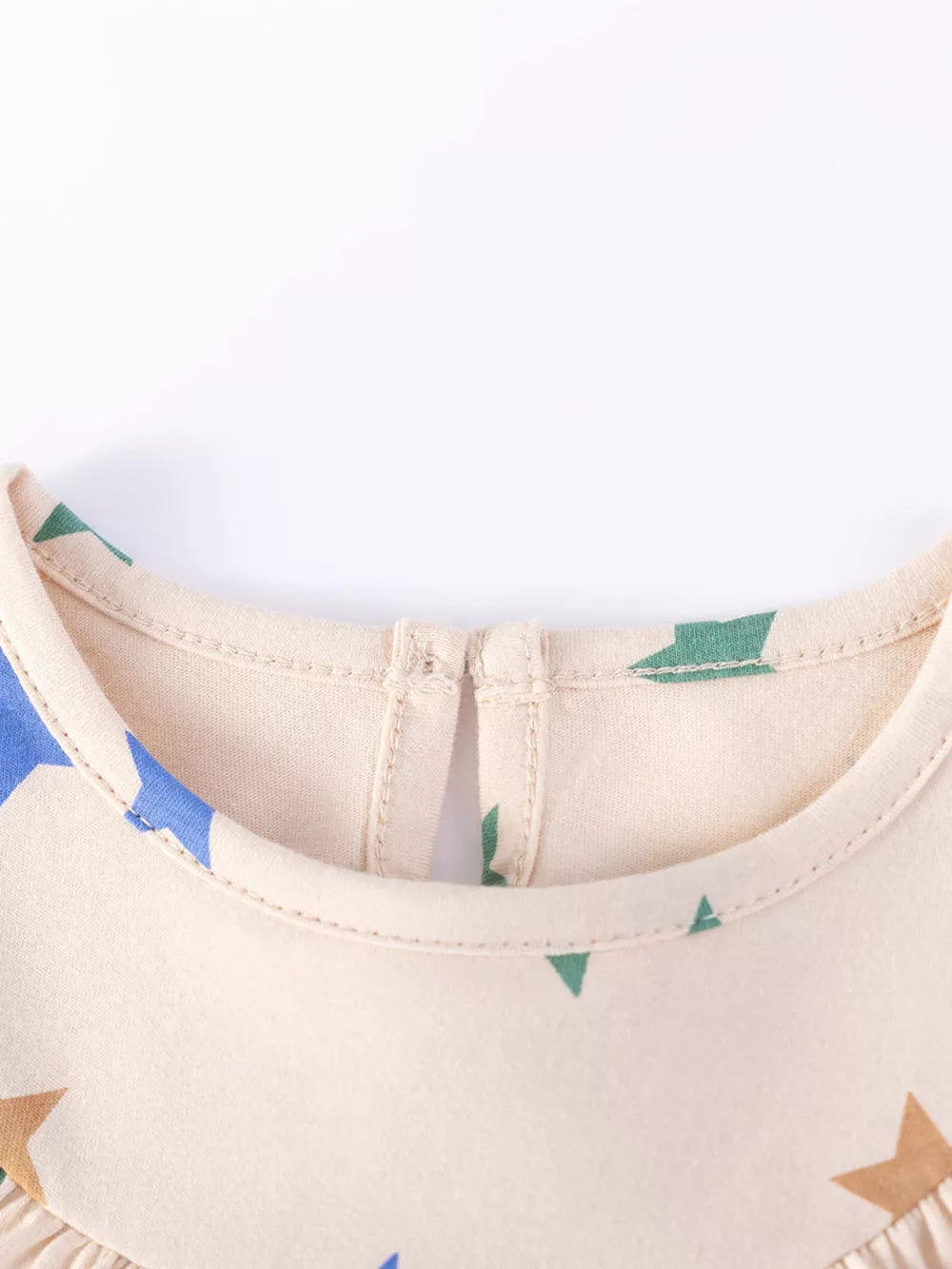 Beige cotton toddler dress with whimsical star print and ruffled detail.