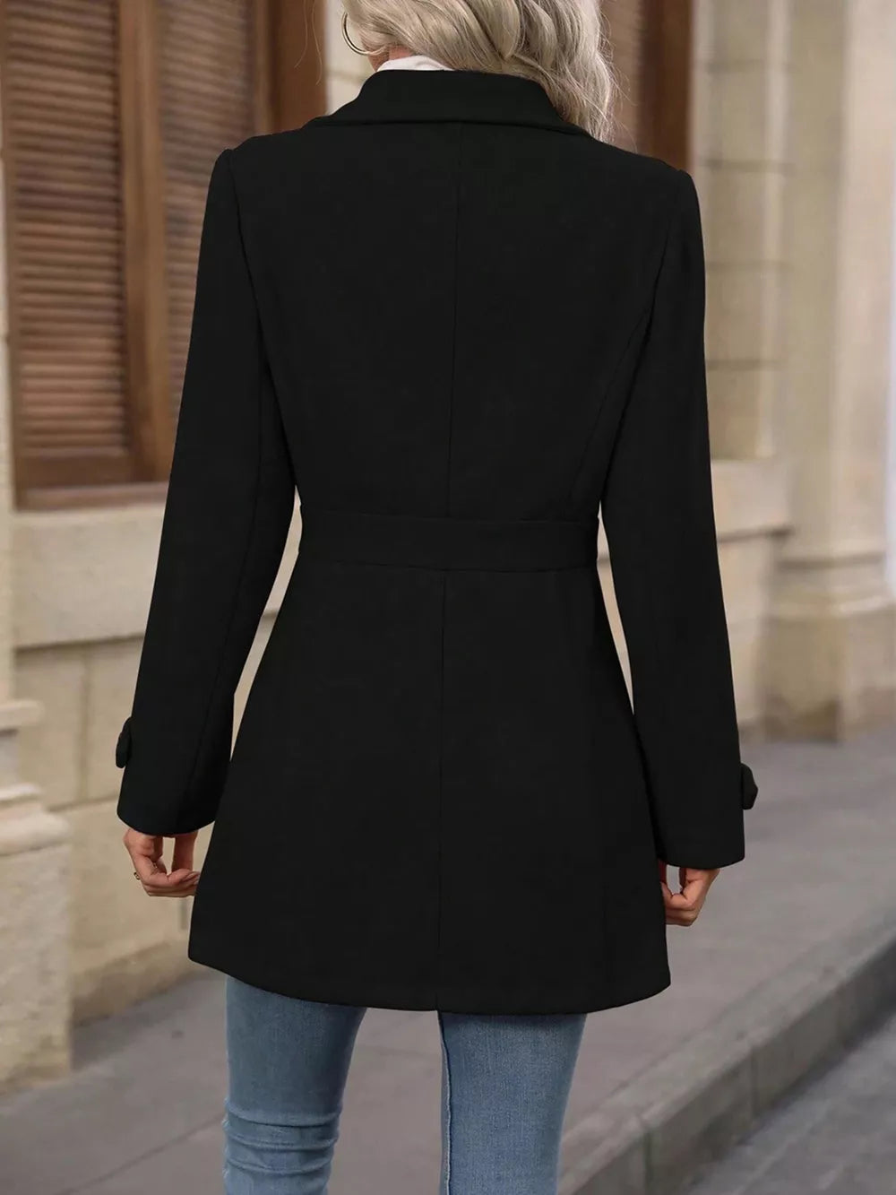 Black button-up trench coat with cinched waist and buttoned cuffs.